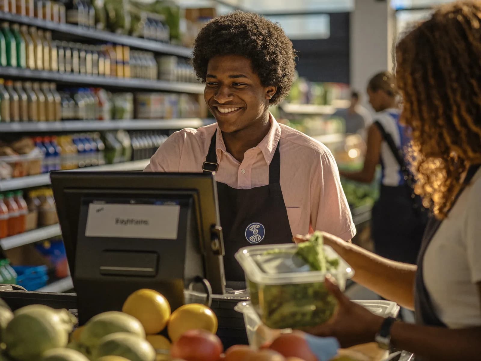 Caissier souriant encaissant des clients dans un supermarché