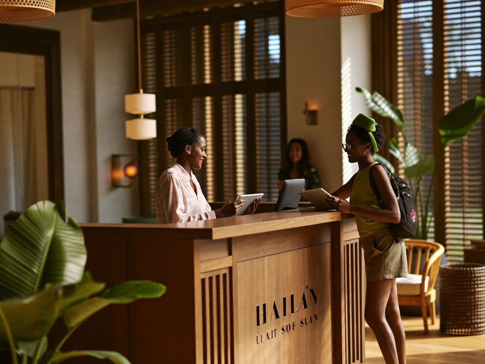 Réceptionniste accueillant une cliente à la réception d'un hôtel